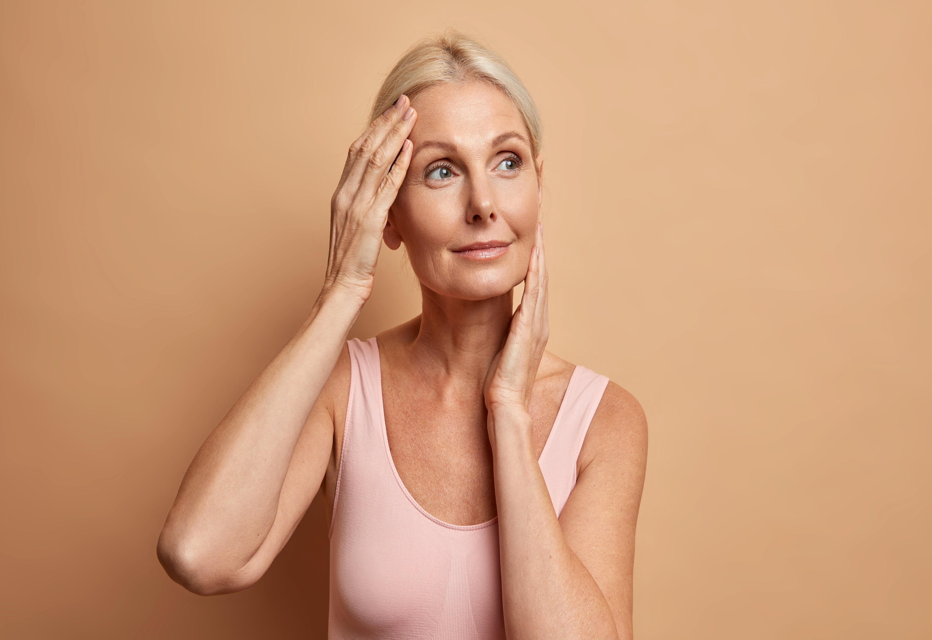 femme avec le sourire se touchant le visage 